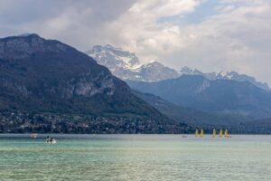 Vue sur un lac alpin et les sommets enneigés depuis une terrasse de café